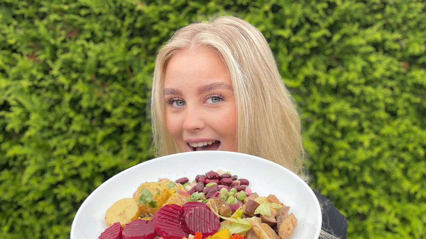 Bilde av jente som holder tallerken med vegetarbuffet