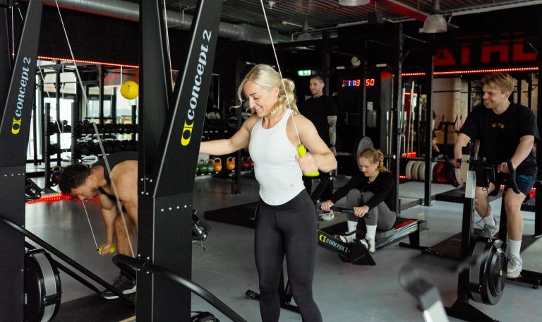 En fornøyd gruppe trener på Athletica Vulkan, på stake- og romaskin, og sykkel. 