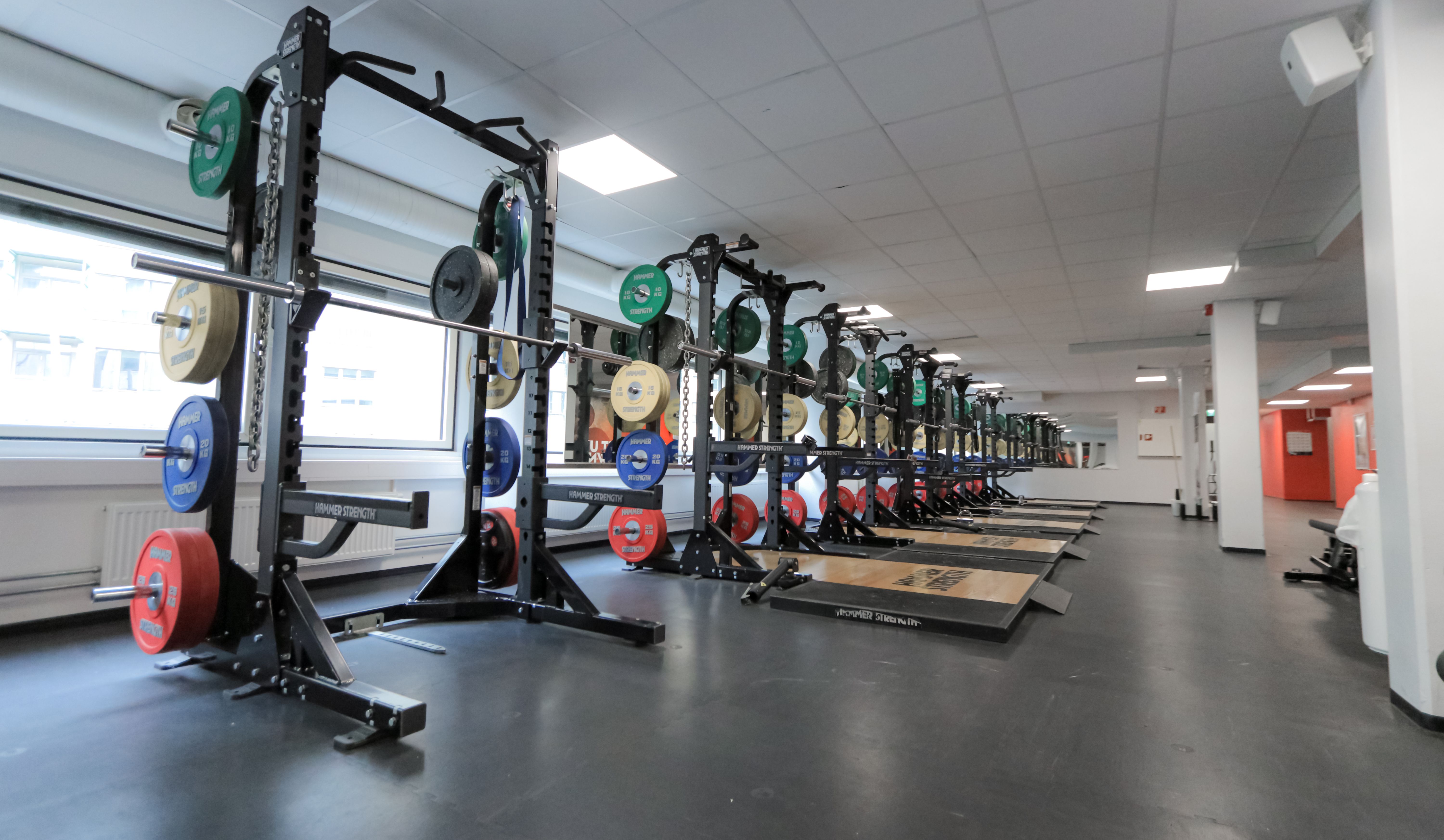 Treningsstudio på Athletica Centrum med blant annet knebøystativ og racks med olympiske vekter.