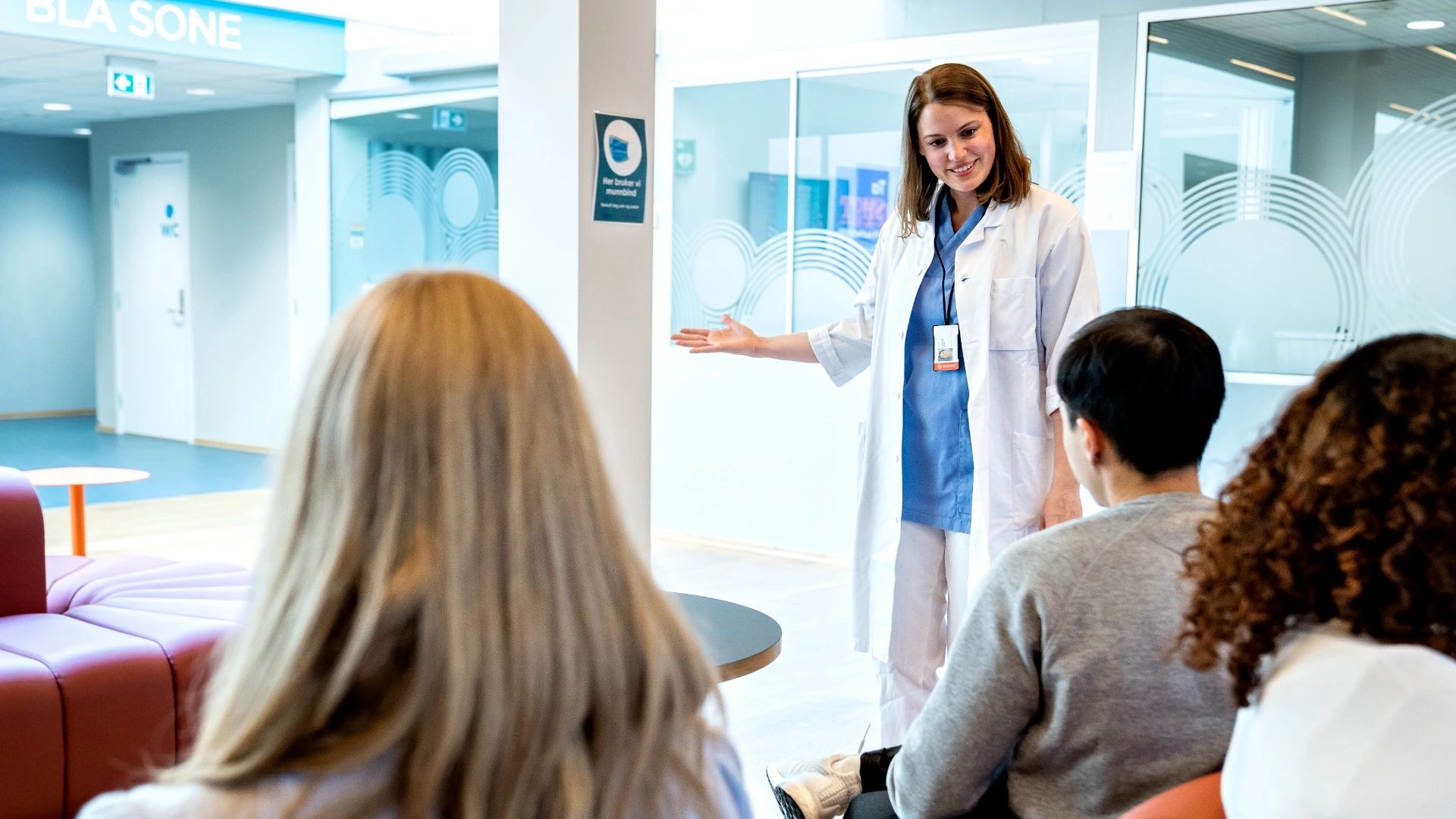 En lege ønsker en pasient velkommen i en resepsjon