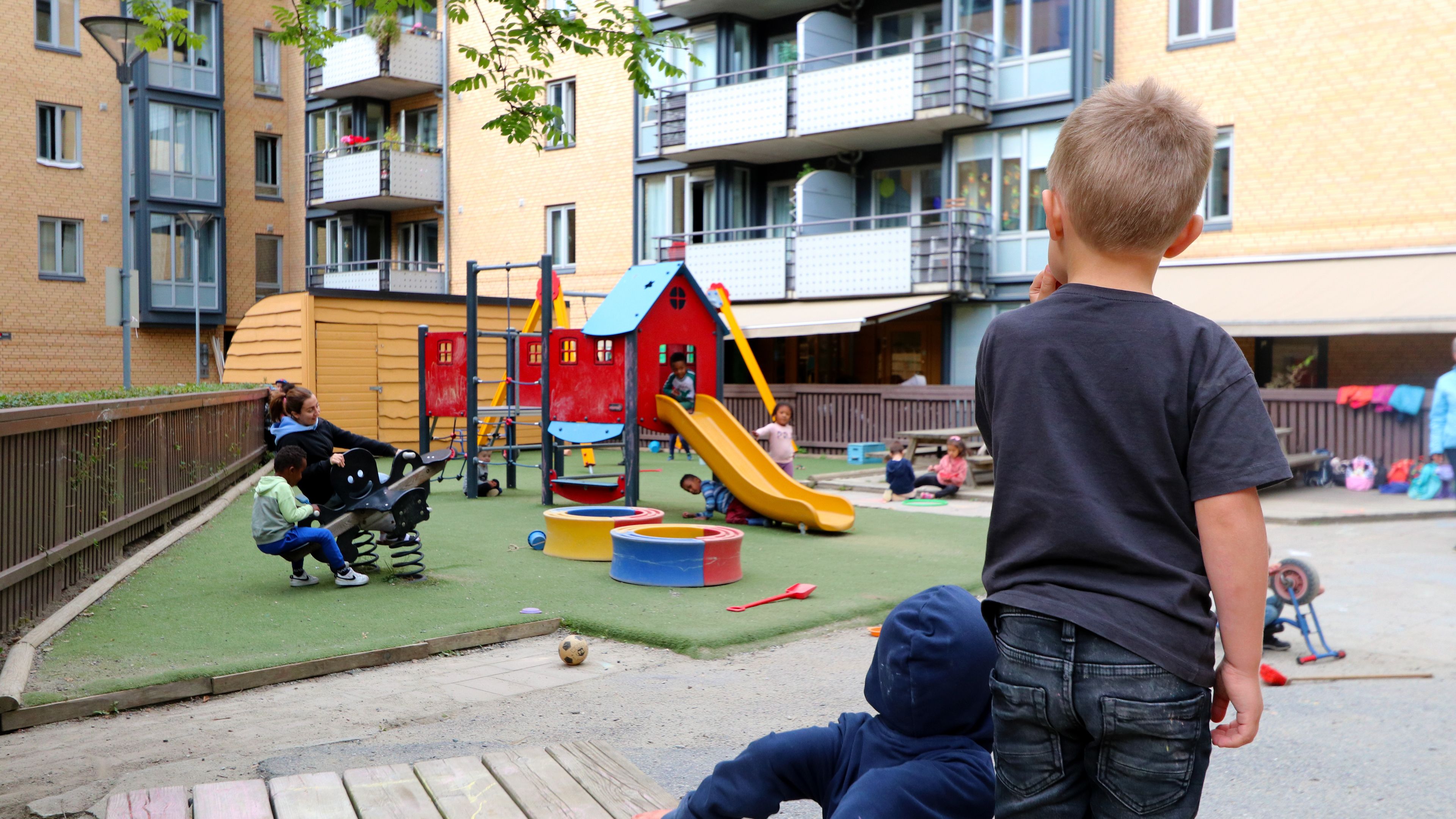 Et barn som ser på en barn og voksen som leker med dumpehuske