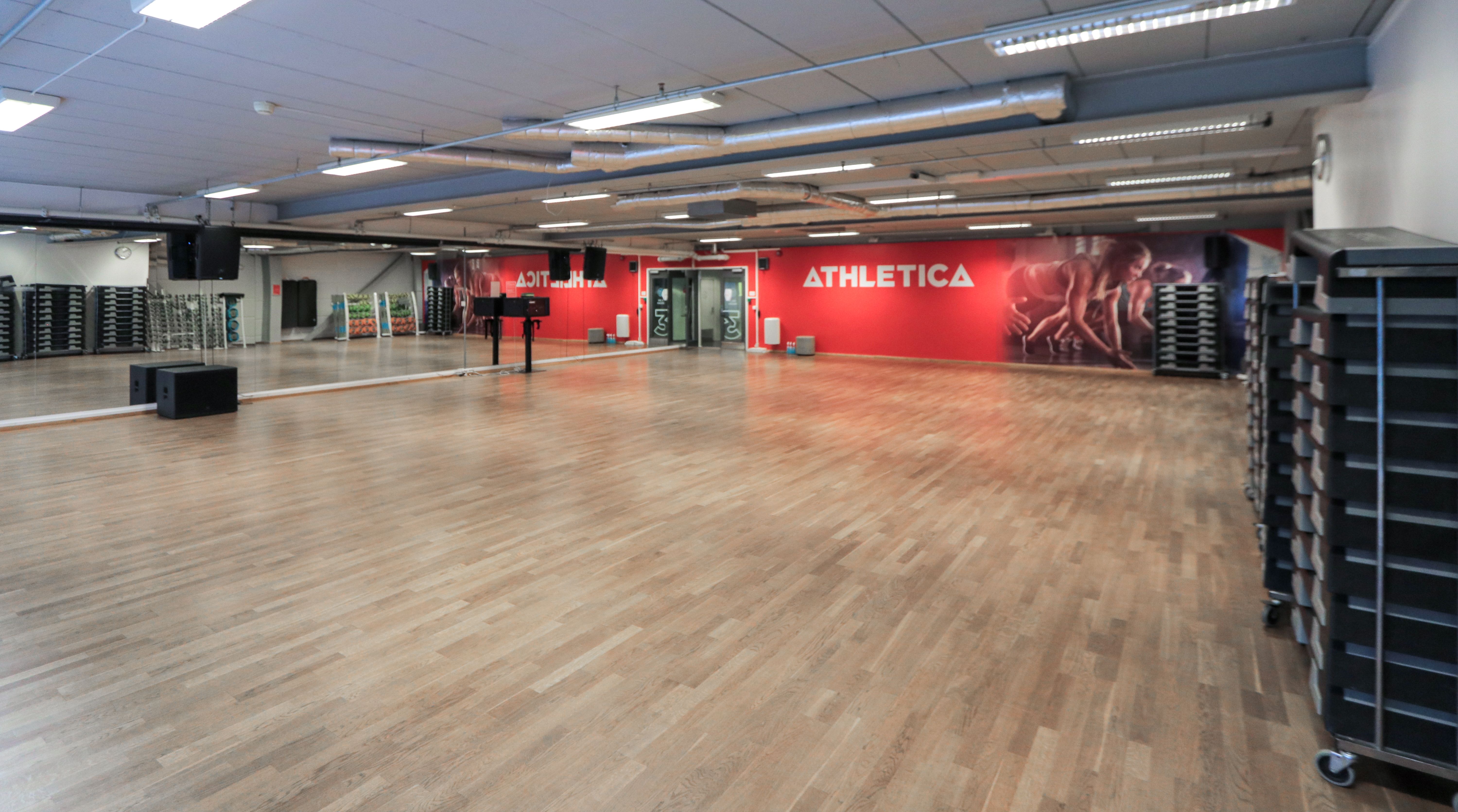 Den store gruppetimesalen på Athletica Vulkan med parkettgulv og speil. 