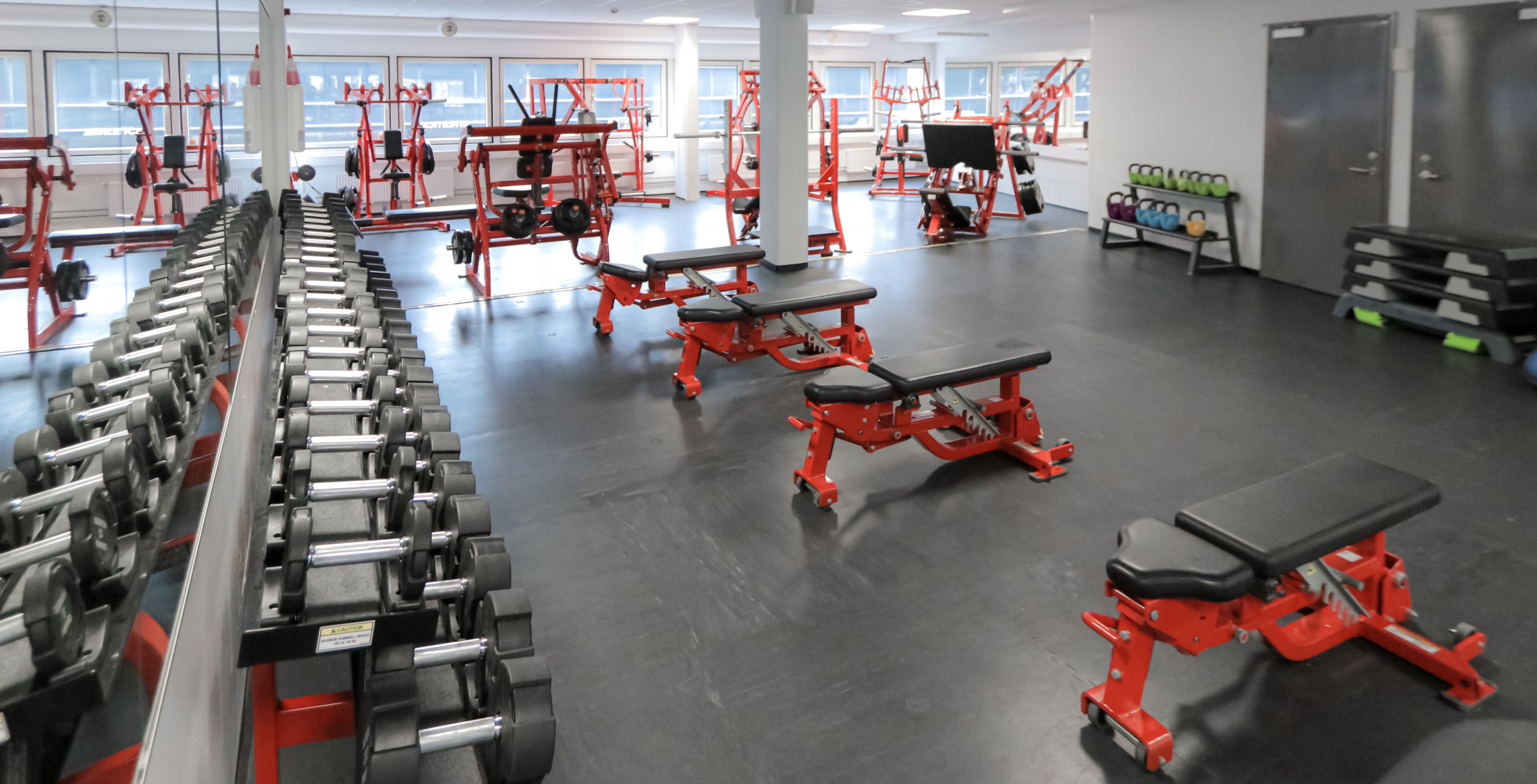 Frivekter og treningsbenker på Athletica Centrum, med apparater i bakgrunnen. 