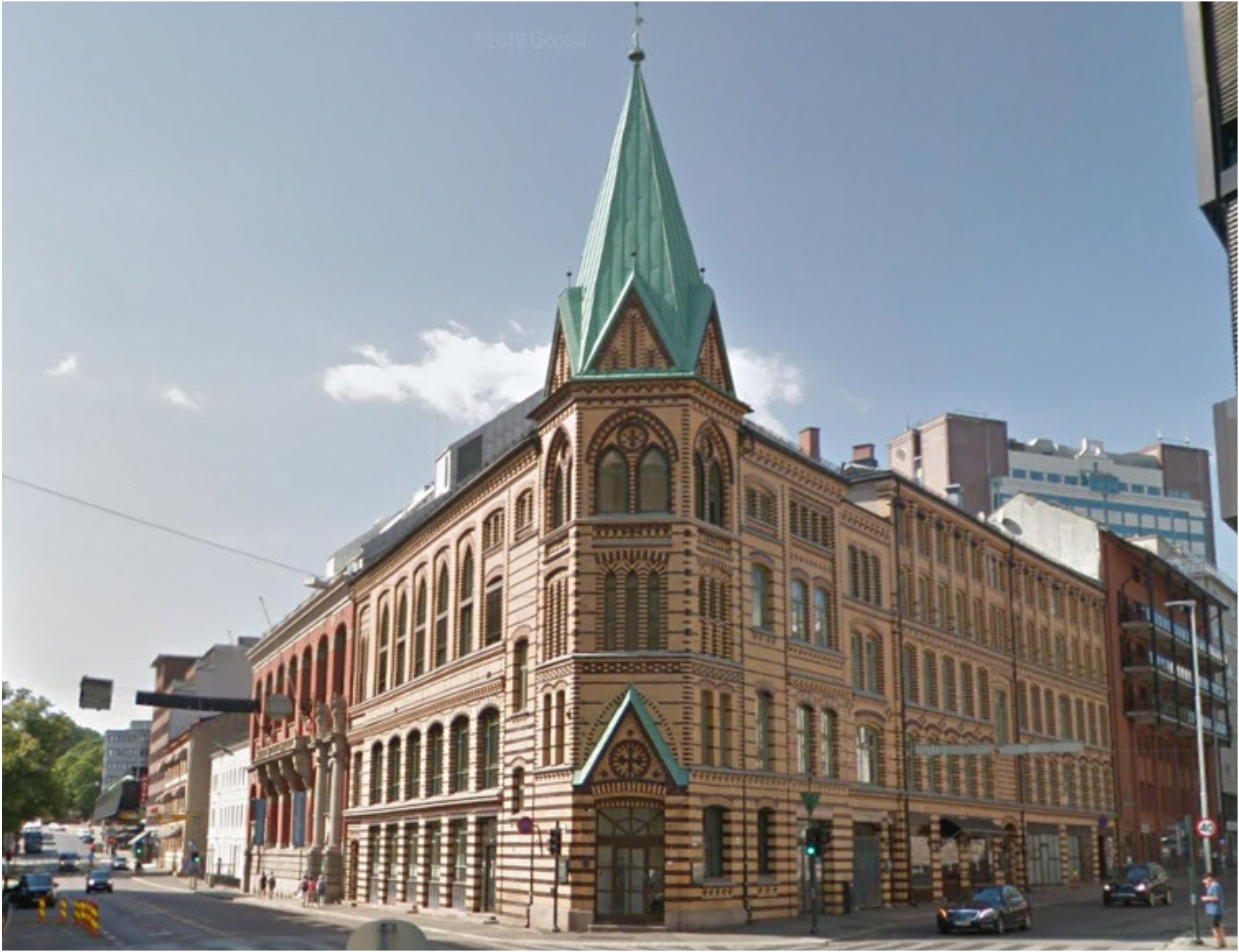 Foto av St. Olavsgate 23, bygg med brun fasade og tårn med spir.