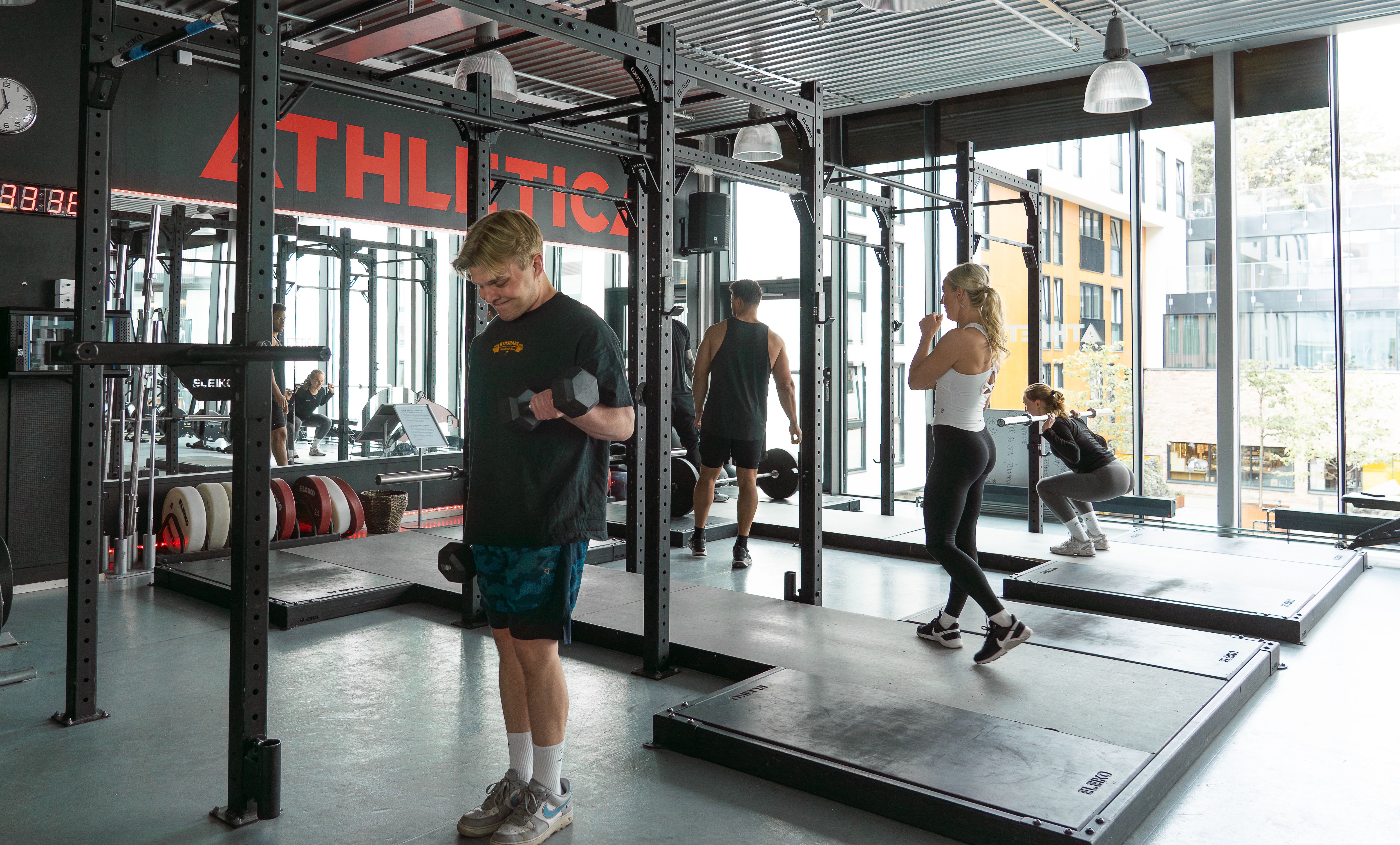 Løfteplattformer på treningssenteret Athletica Vulkan med flere som trener.